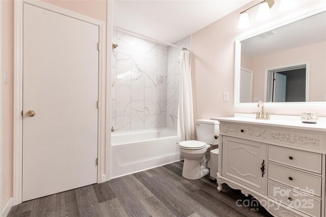 full bath featuring vanity, shower / bath combo with shower curtain, toilet, and wood finished floors