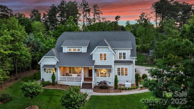 view of front facade with a porch, crawl space, a front yard, and a standing seam roof
