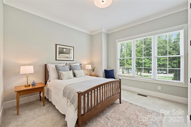 carpeted bedroom with baseboards, ornamental molding, and visible vents