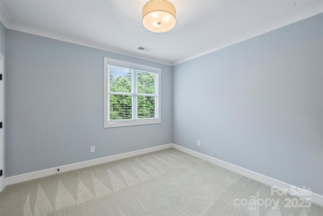 spare room featuring light colored carpet, visible vents, baseboards, and ornamental molding