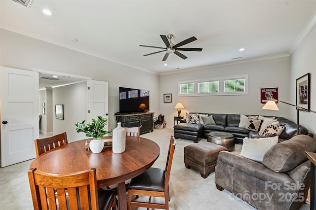living room with a ceiling fan, recessed lighting, ornamental molding, visible vents, and light colored carpet