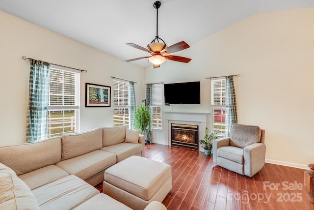 6910 Birdsong Ln, Waxhaw, NC 28173 - living area with dark wood-style floors, a ceiling fan, baseboards, lofted ceiling, and a glass covered fireplace