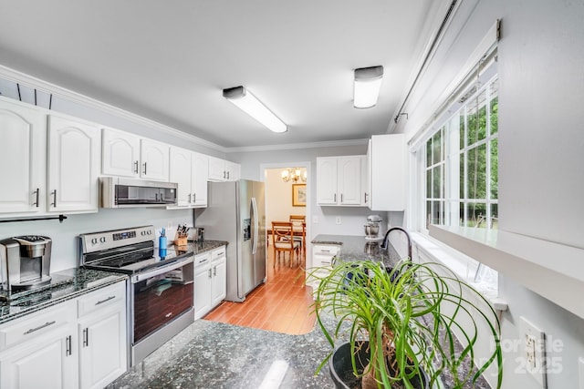 6910 Birdsong Ln, Waxhaw, NC 28173 - kitchen featuring stainless steel appliances, crown molding, white cabinetry, light wood-style flooring, and dark stone countertops