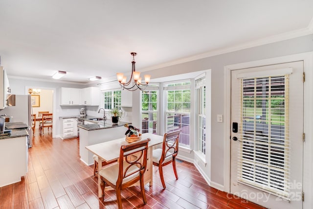 6910 Birdsong Ln, Waxhaw, NC 28173 - dining space featuring a chandelier, ornamental molding, light wood-type flooring, and baseboards