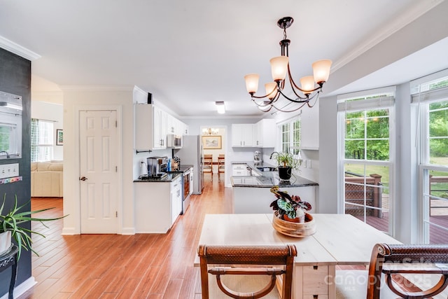 6910 Birdsong Ln, Waxhaw, NC 28173 - dining space featuring ornamental molding, a chandelier, plenty of natural light, and light wood finished floors