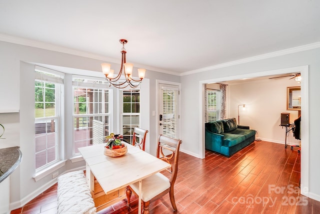 6910 Birdsong Ln, Waxhaw, NC 28173 - dining area with crown molding, a chandelier, baseboards, and wood finished floors