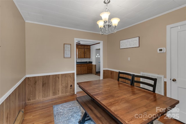 159 Old Home Pl, China Grove, NC 28023 - dining space with crown molding, a wainscoted wall, light wood-style flooring, and a notable chandelier
