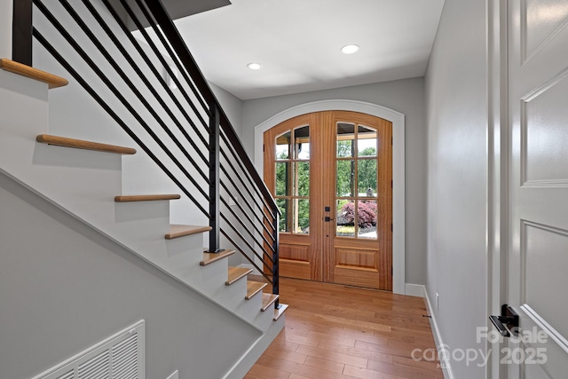 entrance foyer with visible vents, stairway, baseboards, light wood finished floors, and recessed lighting