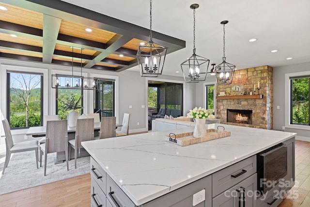 kitchen with recessed lighting, a chandelier, light wood finished floors, and coffered ceiling