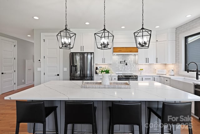 kitchen featuring recessed lighting, a chandelier, tasteful backsplash, a sink, and stainless steel appliances