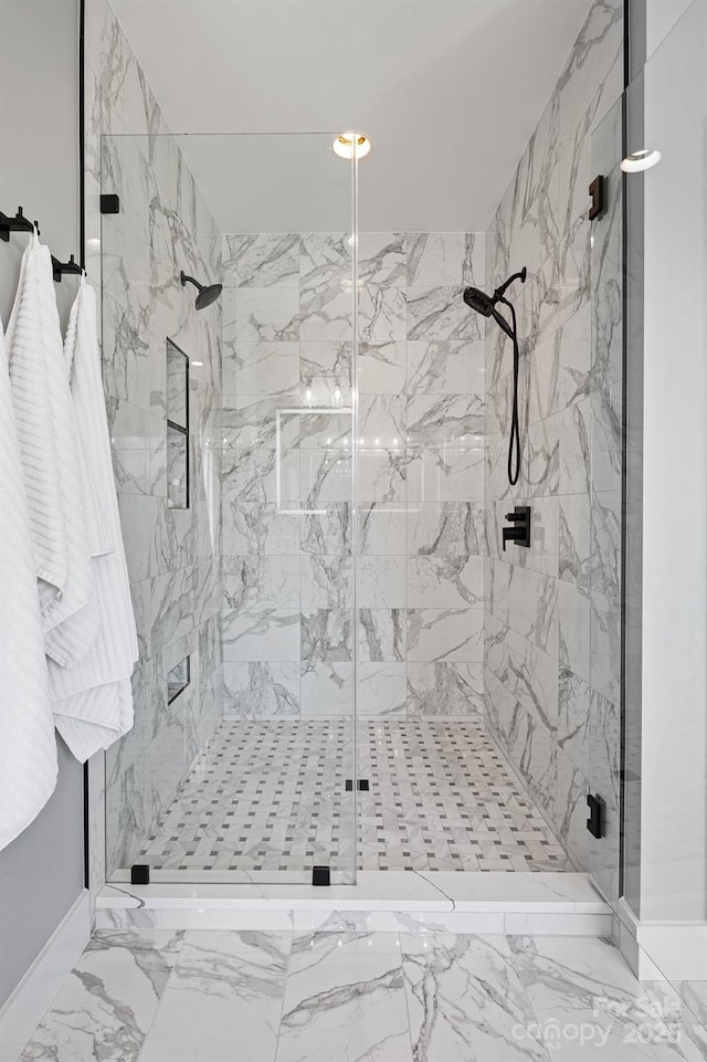 bathroom featuring baseboards, marble finish floor, and a marble finish shower