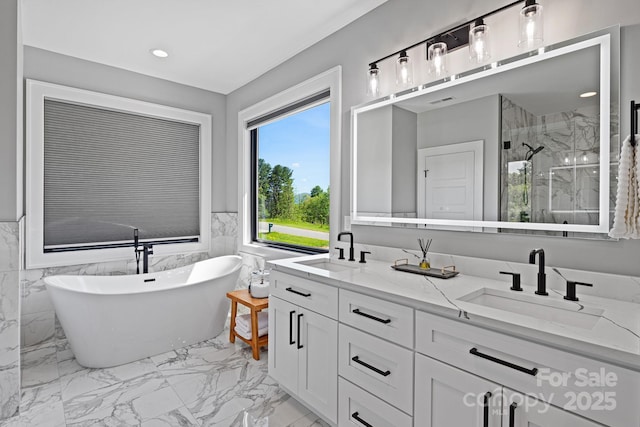 full bathroom featuring a sink, a freestanding tub, a marble finish shower, and marble finish floor