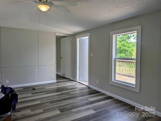 unfurnished room featuring baseboards, a textured ceiling, ceiling fan, and wood finished floors