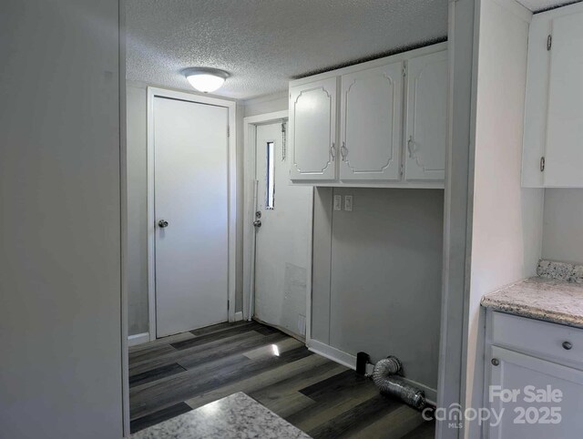 washroom featuring a textured ceiling, laundry area, and wood finished floors