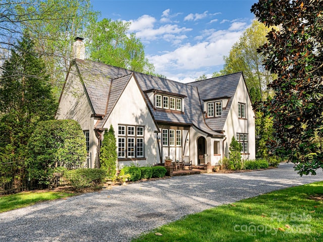 341 Vanderbilt Rd, Asheville, NC 28803 - tudor-style house featuring a chimney, stucco siding, and gravel driveway