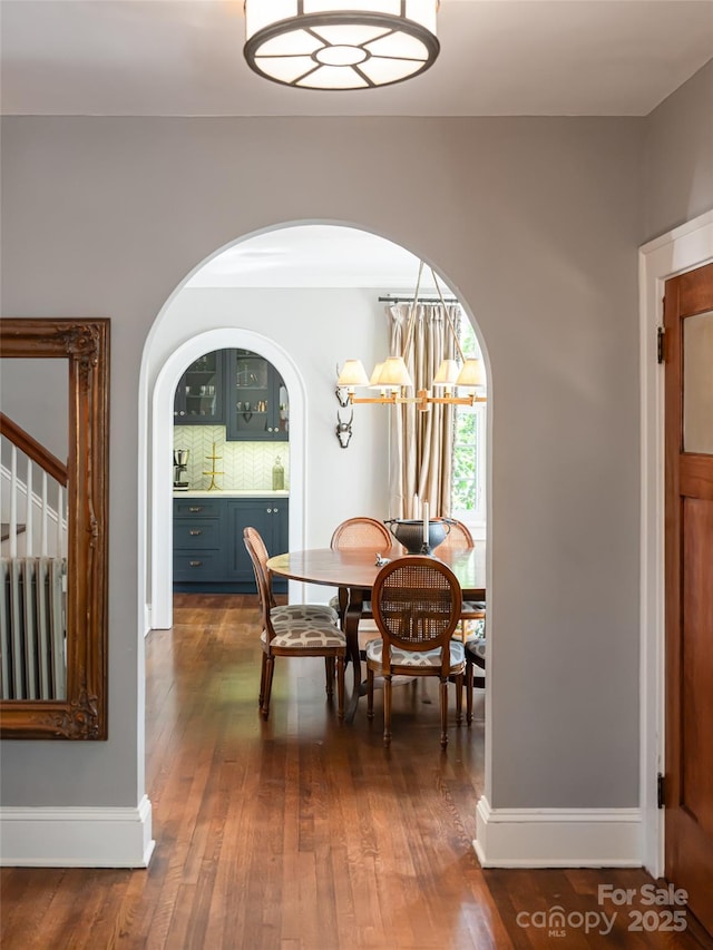 341 Vanderbilt Rd, Asheville, NC 28803 - dining room with arched walkways, baseboards, dark wood-style floors, and stairs
