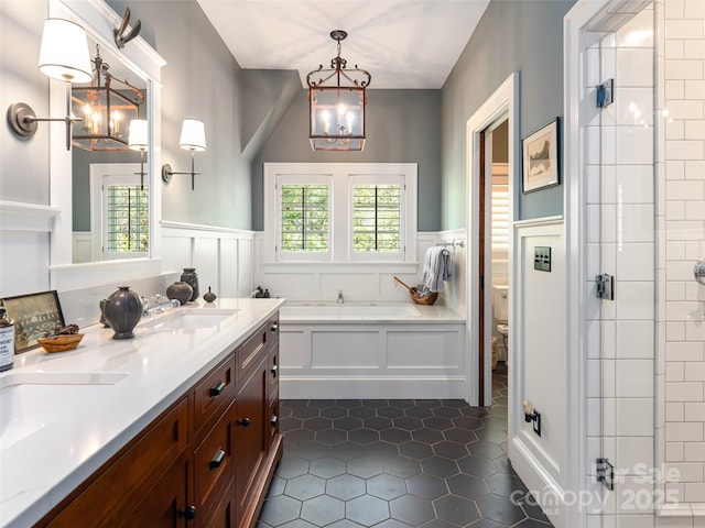 341 Vanderbilt Rd, Asheville, NC 28803 - full bath featuring an inviting chandelier, a tile shower, a decorative wall, tile patterned floors, and a wainscoted wall