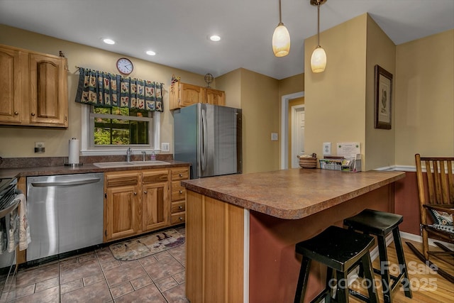 385 N Fork Rd, Black Mountain, NC 28711 - kitchen with dark countertops, a sink, stainless steel appliances, a kitchen bar, and pendant lighting