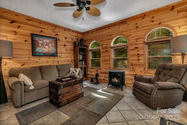 385 N Fork Rd, Black Mountain, NC 28711 - tiled living room with wooden walls, ceiling fan, and a wood stove
