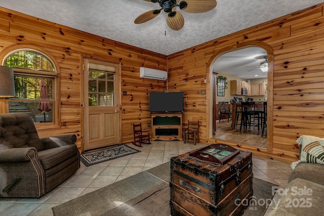 385 N Fork Rd, Black Mountain, NC 28711 - tiled living room with a ceiling fan, arched walkways, wood walls, and a wall mounted AC