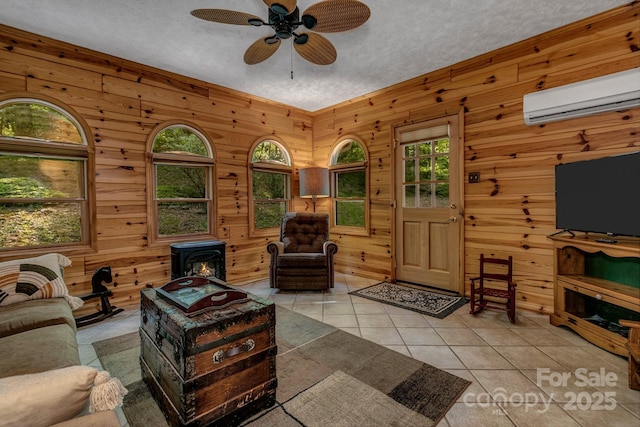 385 N Fork Rd, Black Mountain, NC 28711 - living area with ceiling fan, a wood stove, an AC wall unit, a textured ceiling, and light tile patterned floors
