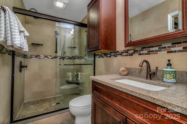 385 N Fork Rd, Black Mountain, NC 28711 - full bathroom featuring vanity, a stall shower, toilet, and tile walls