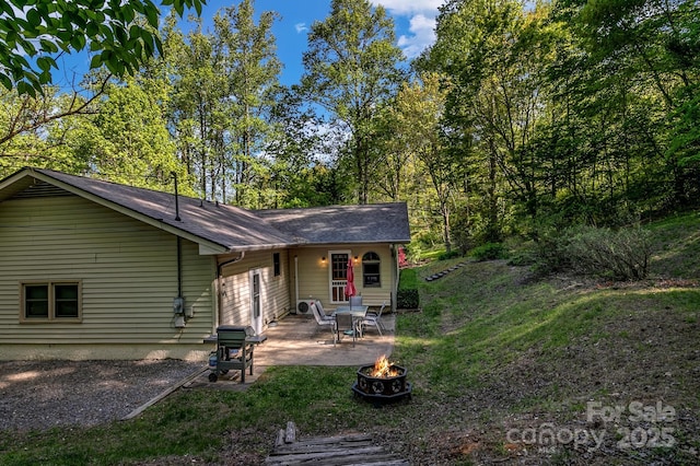 385 N Fork Rd, Black Mountain, NC 28711 - rear view of property featuring roof with shingles, a patio, and a fire pit