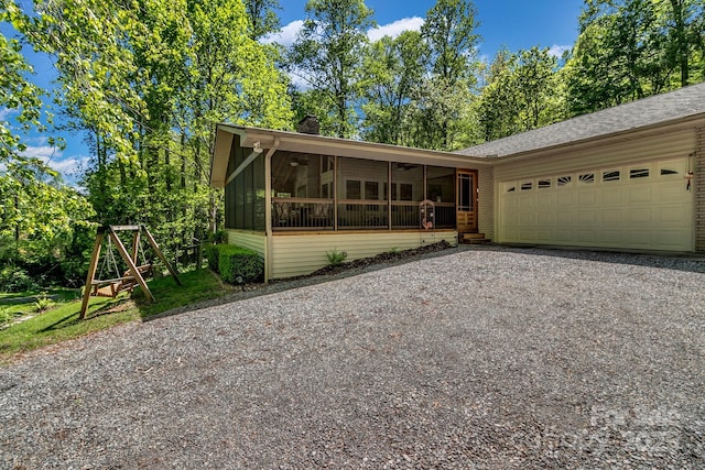 385 N Fork Rd, Black Mountain, NC 28711 - view of front of house featuring driveway, a ceiling fan, a chimney, a sunroom, and an attached garage