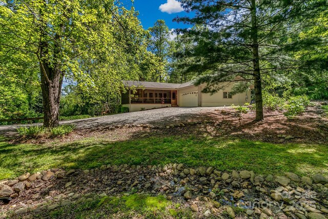 385 N Fork Rd, Black Mountain, NC 28711 - view of front of home featuring an attached garage, a sunroom, and gravel driveway