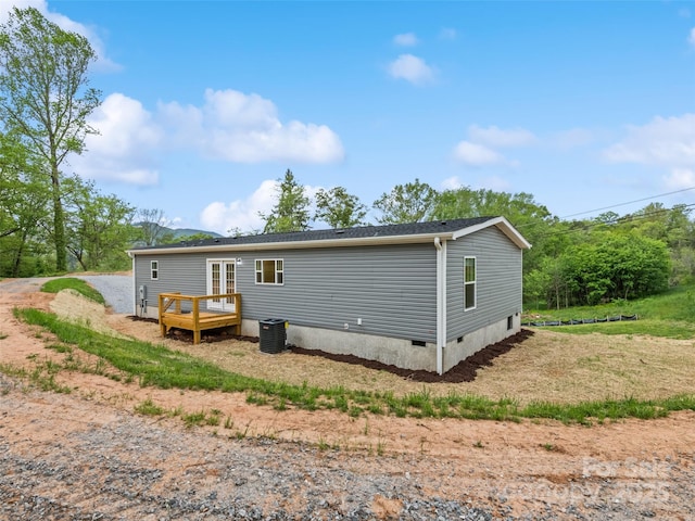 back of house with crawl space, a wooden deck, and central AC unit