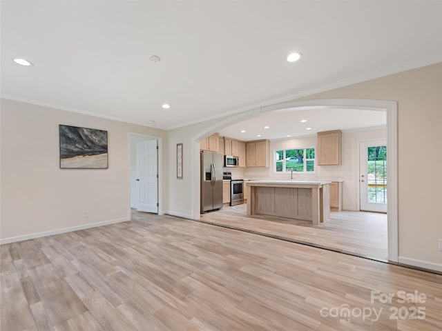 kitchen with crown molding, arched walkways, appliances with stainless steel finishes, and light brown cabinets