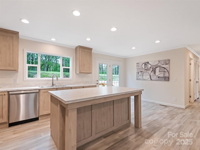 kitchen featuring stainless steel dishwasher, light brown cabinetry, crown molding, and a sink