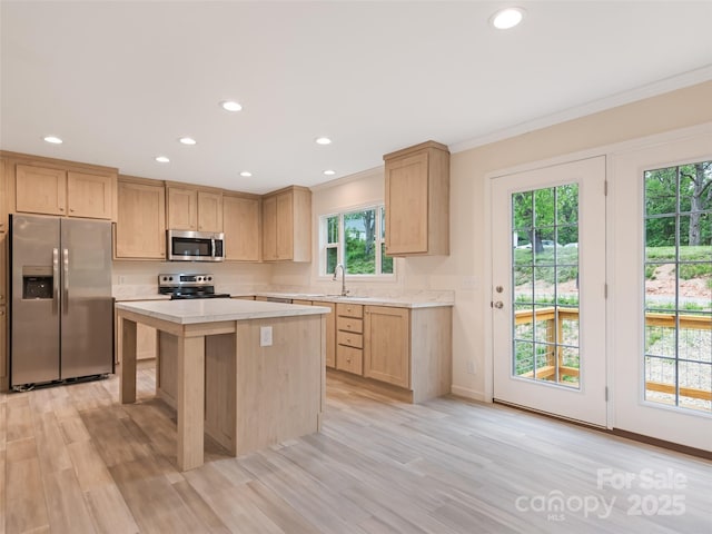 kitchen featuring light countertops, ornamental molding, stainless steel appliances, and recessed lighting