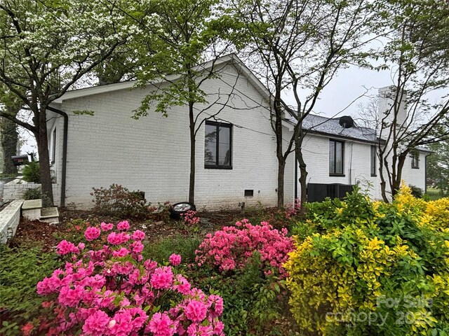 view of side of property featuring brick siding and crawl space
