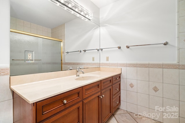 117 Distant View Dr, Asheville, NC 28803 - bathroom with tile walls, a shower with door, vanity, wainscoting, and tile patterned flooring