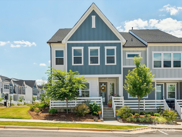 view of front of home with a shingled roof, board and batten siding, and covered porch