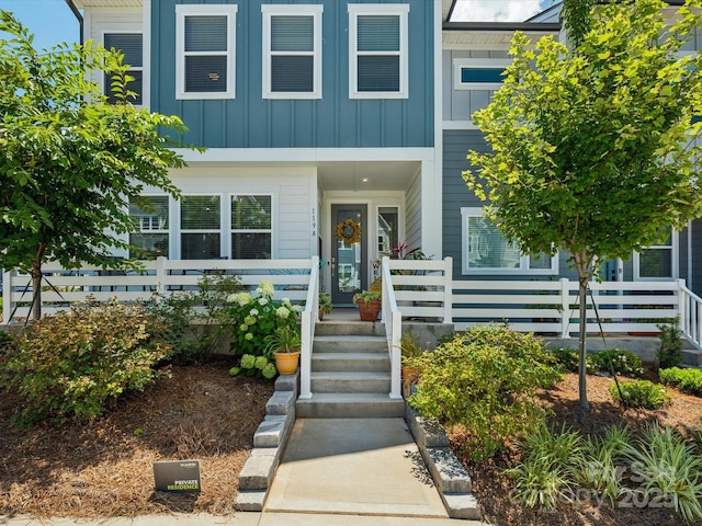 view of front of property with board and batten siding and fence