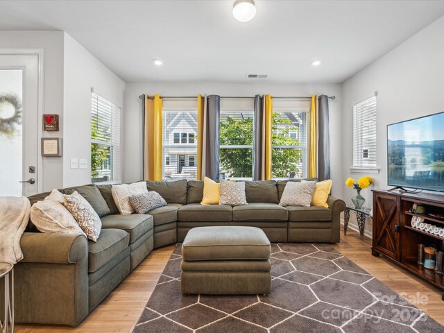 living area featuring recessed lighting, wood finished floors, and visible vents