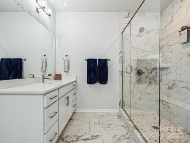 full bath with baseboards, a marble finish shower, marble finish floor, and vanity