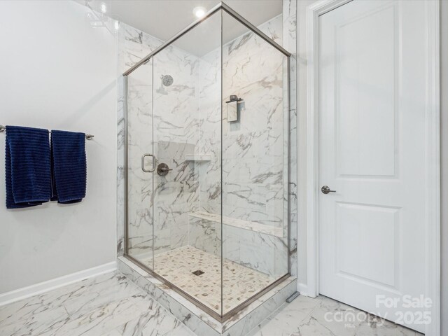 full bathroom featuring baseboards, a marble finish shower, and marble finish floor