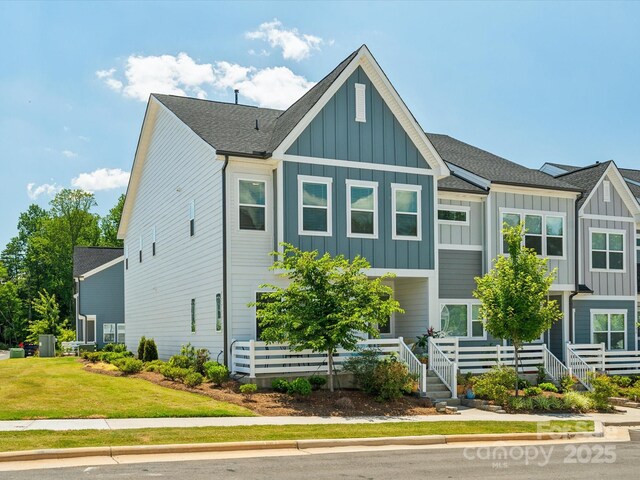 townhome / multi-family property featuring board and batten siding and a front yard