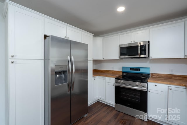 1411 Caldwell St, Gastonia, NC 28052 - kitchen with butcher block counters, dark wood-type flooring, recessed lighting, white cabinetry, and appliances with stainless steel finishes