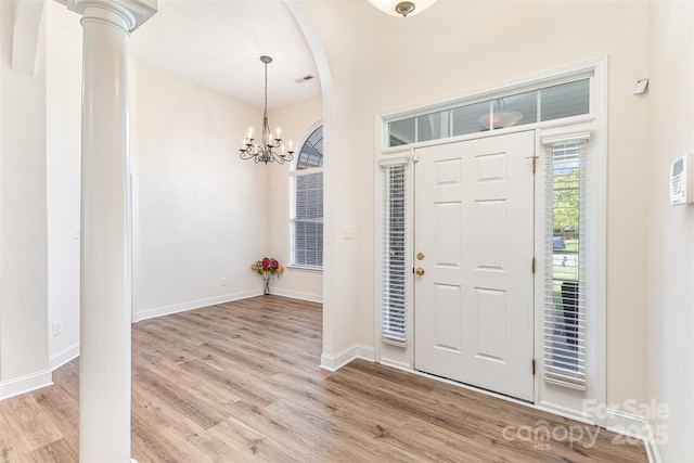 entryway featuring light wood-style floors, a chandelier, and baseboards