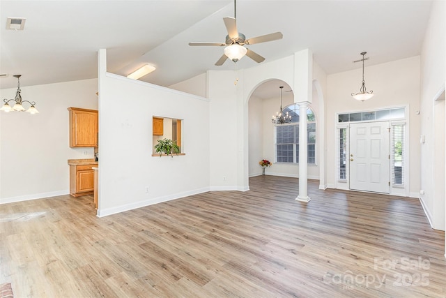 unfurnished living room featuring a chandelier, arched walkways, light wood-type flooring, high vaulted ceiling, and a ceiling fan