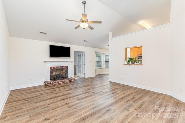 unfurnished living room with a fireplace, a ceiling fan, light wood-type flooring, vaulted ceiling, and baseboards