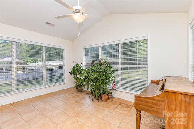 sitting room featuring vaulted ceiling, light tile patterned floors, and a ceiling fan