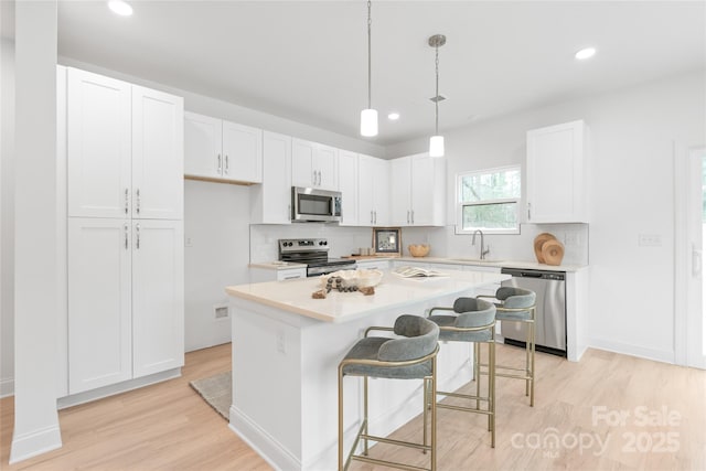 kitchen with stainless steel appliances, recessed lighting, a sink, and light wood-type flooring