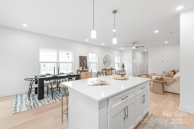 kitchen with a center island, recessed lighting, light wood finished floors, and white cabinetry