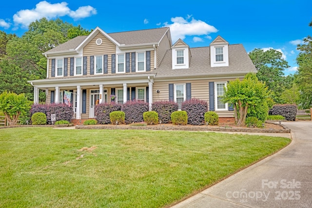 colonial-style house with a front lawn, covered porch, and a shingled roof