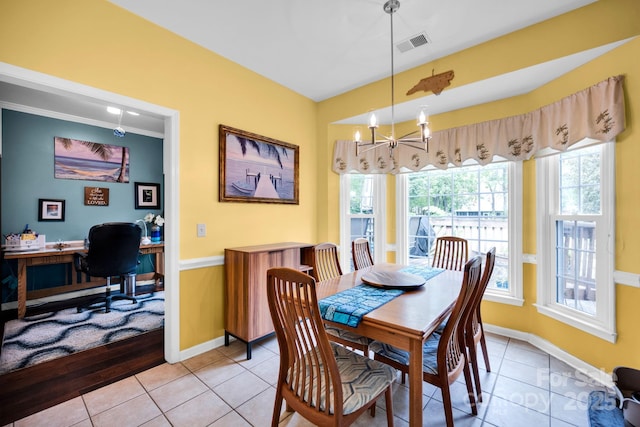 dining room with healthy amount of natural light, light tile patterned flooring, a chandelier, and baseboards